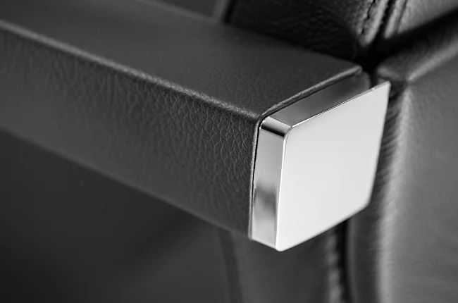 Close-up on the polished aluminum armrest with its plush padding.